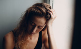 Woman runs hand through hair, appears distressed.