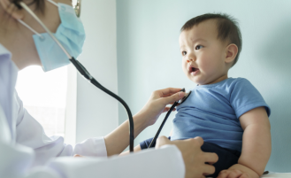 Doctor examines baby in office.