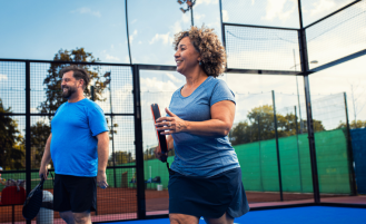 Woman and man on court playing game of pickleball.