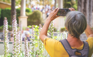 Older woman takes photo with her cellphone while traveling.