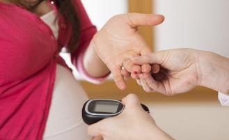 A pregnant patient takes a blood glucose test 