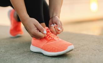 A person lacing up their shoe getting ready for a workout