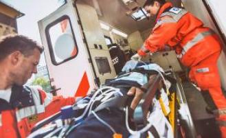 EMT's loading an injured person into an ambulance.