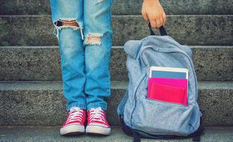 child holding backpack on stairs