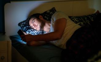 man-staring-at-smartphone-in-bed