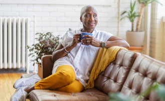 Woman sits with cup of coffee.