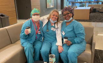 Three Overlake nurses smiling and sitting on couch together.