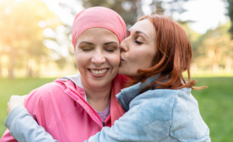 Woman embraces friend with cancer.
